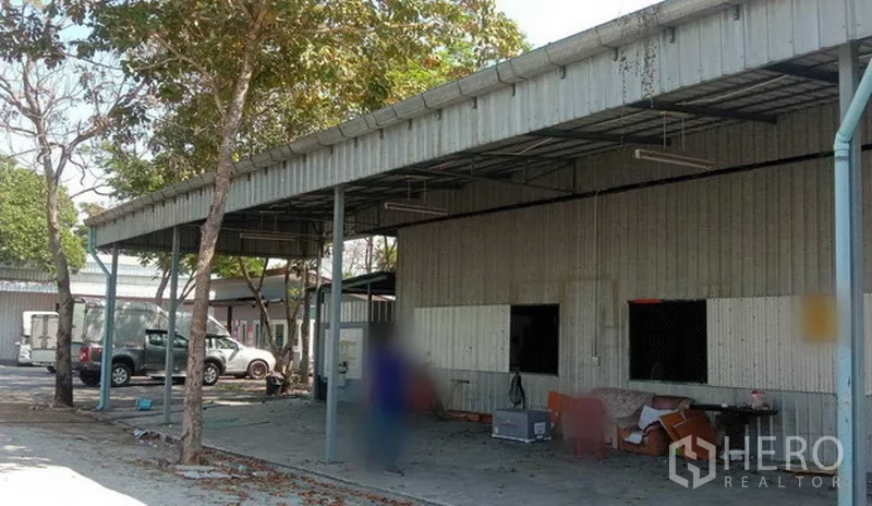 货栈 出租在Khlong Sam Wa, Bangkok - 曼谷Khlong Sam Wa区金属外墙仓库外立面，带雨棚装卸区与宽阔硬质场地。