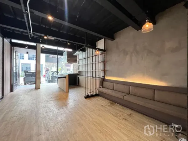 店屋 出租 - 一层开放式零售空间，整面玻璃、内置长椅与吊灯。