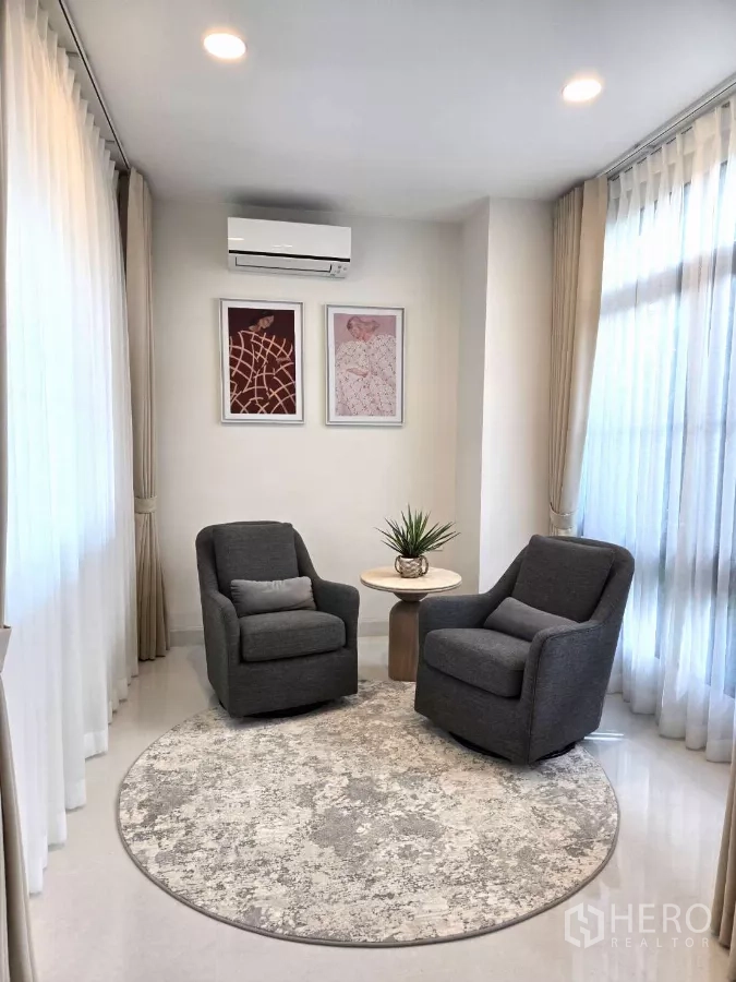 Detached House for rent in Saphan Sung, Bangkok - Cozy sitting area with two armchairs and circular rug by the windows.