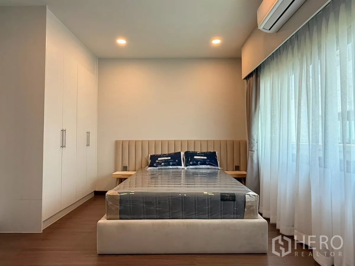 Detached House for rent in Bang Phli, Samut Prakan - Bright secondary bedroom with built-in wardrobes, upholstered headboard and large windows.