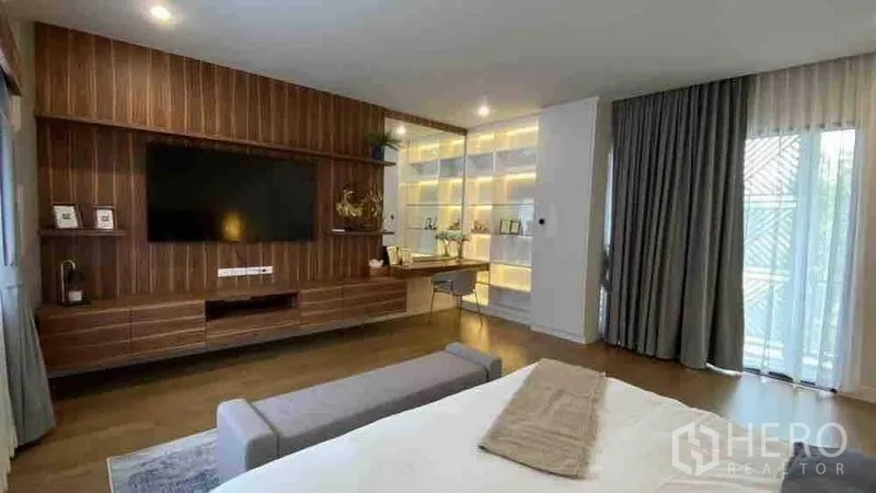 Detached House for rent or sale in Prawet, Bangkok - Master suite with built-in TV wall, study desk and illuminated display shelves.