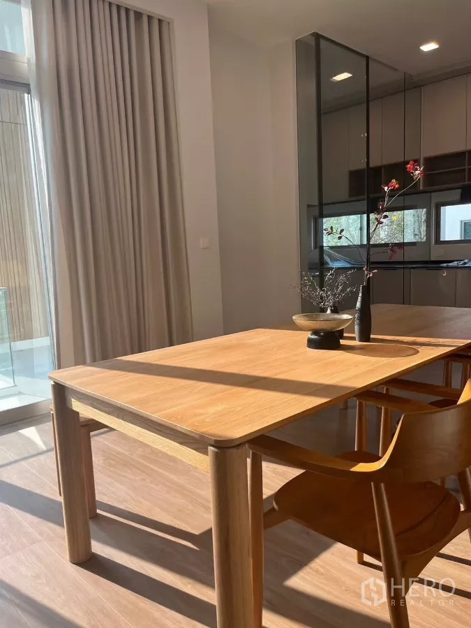 独立式住宅 出租在Saphan Sung, Bangkok - 阳光餐角，极简木桌与餐椅，旁为玻璃隔断。
