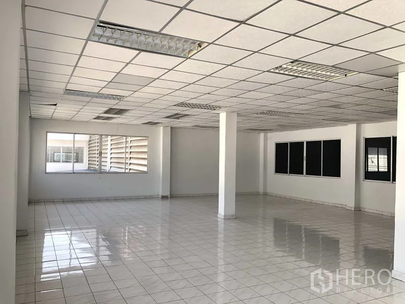 货栈 出租在Phra Nakhon Si Ayutthaya - 办公室一角，白色立柱、日光灯与玻璃窗。