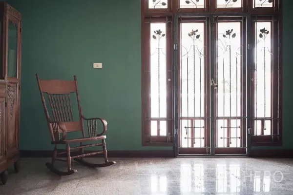 ทาวน์เฮาส์ ให้เช่าในKhlong Toei, Bangkok - พื้นที่นั่งเล่นสว่างไสวพร้อมเก้าอี้โยกและประตูกระจกสูง