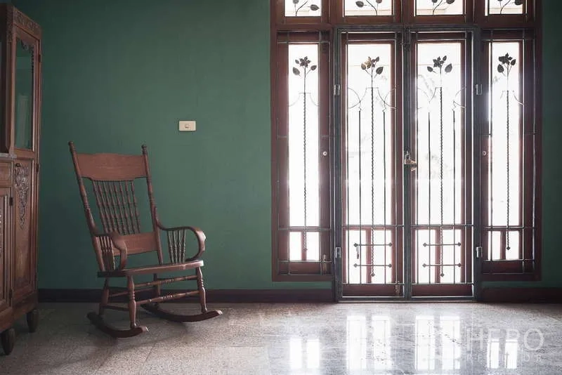 ทาวน์เฮาส์ ให้เช่าในKhlong Toei, Bangkok - พื้นที่นั่งเล่นสว่างไสวพร้อมเก้าอี้โยกและประตูกระจกสูง