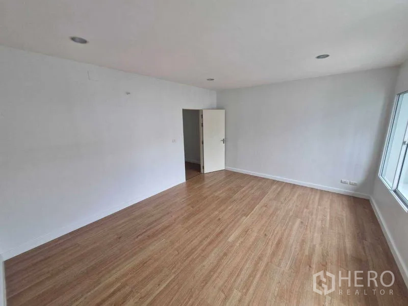 独立式住宅 出售在Rat Burana, Bangkok - 楼上宽敞房间，木地板与白墙