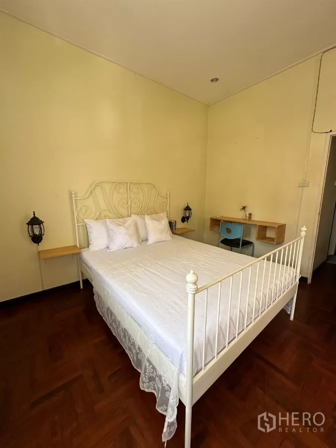 สำนักงานที่บ้าน ให้เช่าในSuan Luang, Bangkok - มุมมองอีกด้านของห้องนอน เตียงเหล็กสีขาวและโต๊ะทำงาน