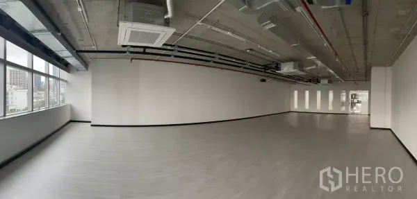 办公空间 出租在Bang Rak, Bangkok - 开放式办公室全景，长排窗户与天花嵌入式空调机组。