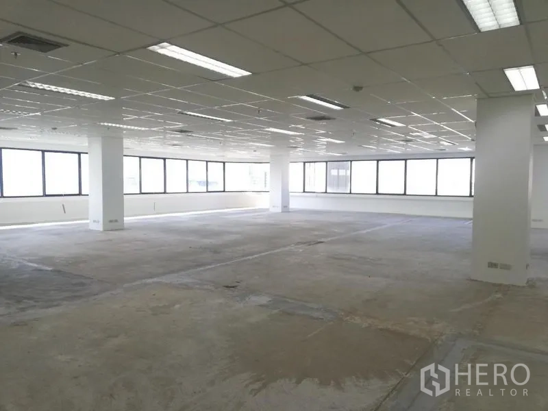 Office Space for rent in Watthana, Bangkok - Bright open‑plan office floor with large windows, grid ceiling lights, and columns ready for fit‑out in Sukhumvit, Bangkok.