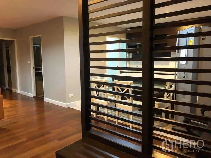 公寓 出售在Yan Nawa, Bangkok - 开放式起居区，木质百叶隔断，前方可见餐区与厨房。