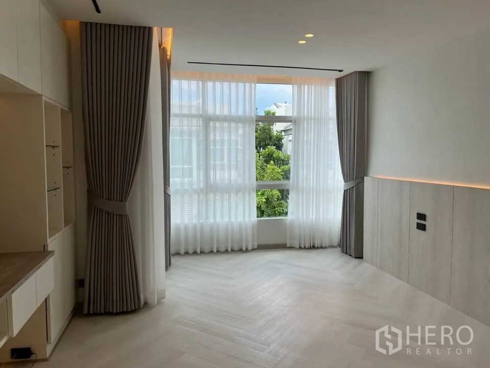 Townhouse for rent in Prawet, Bangkok - Corner window area with full-height curtains and garden outlook.