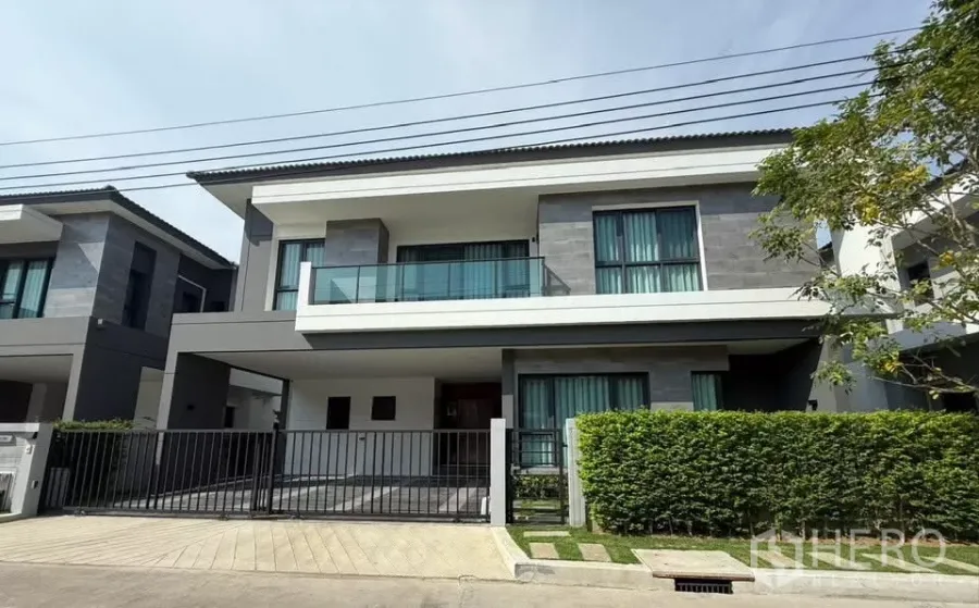 Detached House for rent in Bang Phli, Samut Prakan - Modern two-storey detached house at The City Bangna with gated driveway and trimmed hedge.
