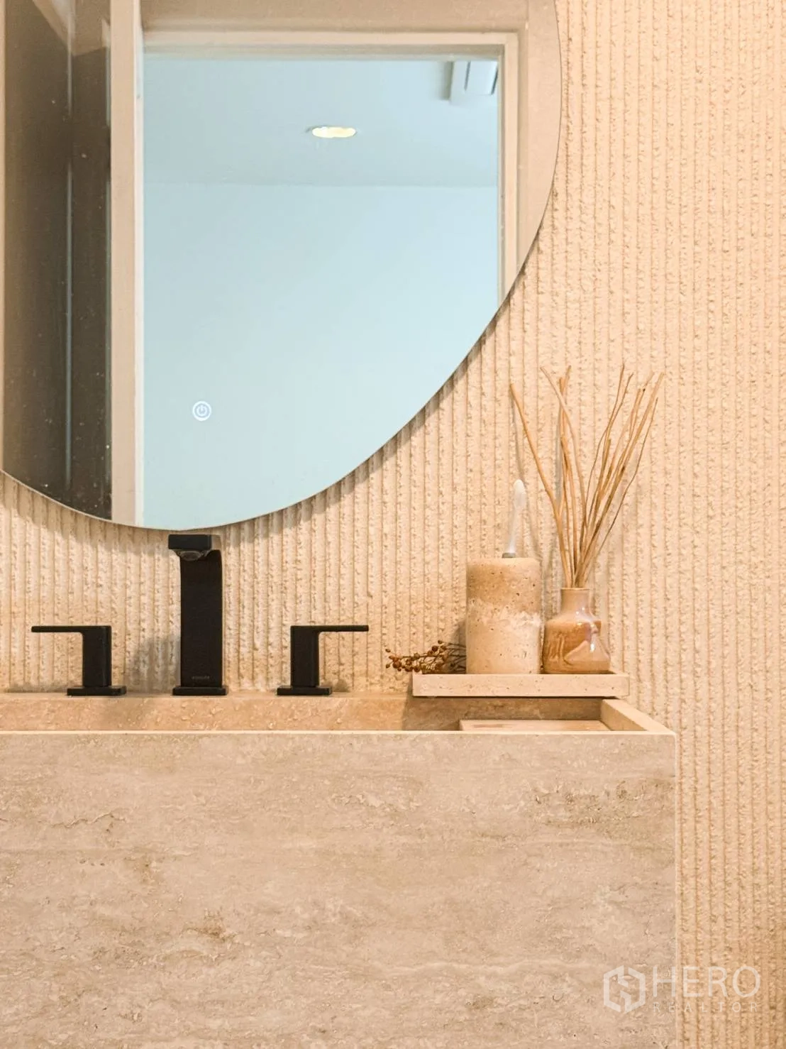 Shophouse for sale in Watthana, Bangkok - Stone vanity with matte black faucet and a large round mirror in a bathroom.