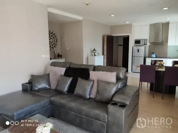 คอนโด ให้เช่าหรือขายในPathum Wan, Bangkok - พื้นที่นั่งเล่นและครัวแบบเปิด โซฟาสีเทา โต๊ะทานอาหารสไตล์ไอแลนด์ และเครื่องใช้สแตนเลส