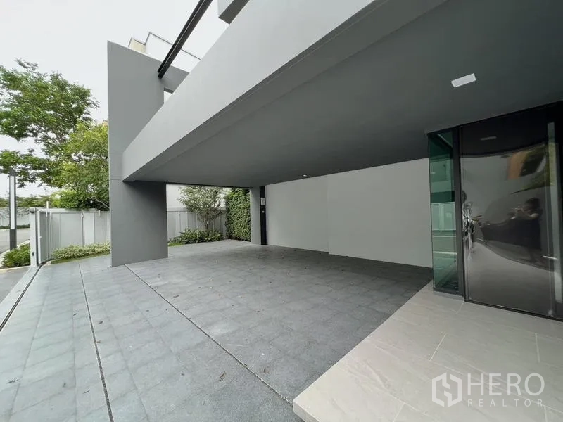 บ้าน ให้เช่าหรือขายในSaphan Sung, Bangkok - ที่จอดรถในร่มใต้ตัวบ้านพร้อมประตูรั้วและสวนแนวเขียว