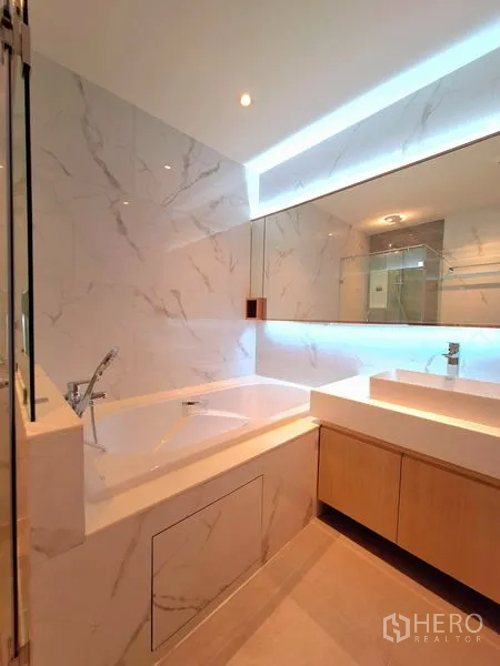 อพาร์ทเมนท์ ให้เช่าในBang Na, Bangkok - ห้องน้ำพร้อมอ่างอาบน้ำ กระจกมีไฟ และเคาน์เตอร์ซิงก์สมัยใหม่
