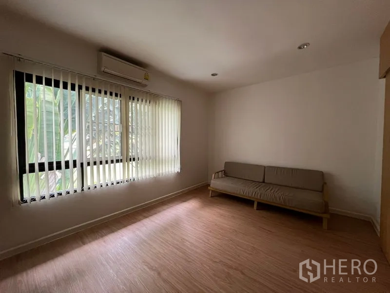 Townhouse for rent in Bang Kapi, Bangkok - Another angle of living room showing sofa and natural light.
