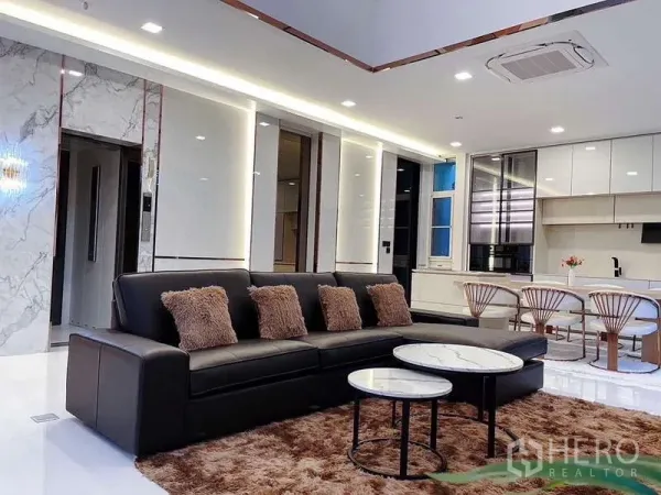 Detached House for rent in Bueng Kum, Bangkok - Contemporary lounge with black leather sofa, nesting marble tables and recessed ceiling lighting.