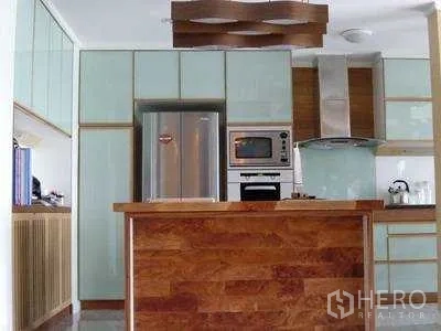 คอนโด ให้เช่าหรือขายในWatthana, Bangkok - ครัวเปิดพร้อมเคาน์เตอร์บาร์ไม้ ตู้เย็นสแตนเลสและเครื่องดูดควัน ในคอนโดเอกมัย