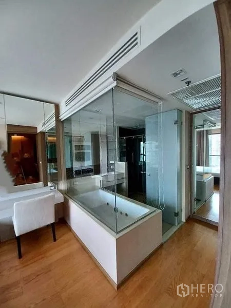 Condominium for rent or sale in Bang Rak, Bangkok - Contemporary bathroom featuring a glass-enclosed soaking tub, separate shower and mirrors.