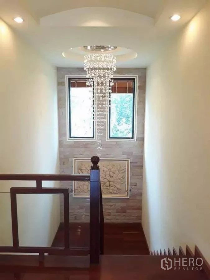 Detached House for sale in Bueng Kum, Bangkok - Stair landing with crystal chandelier and twin windows.
