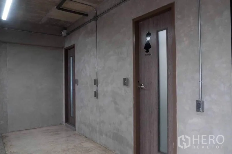 店屋 出租或出售在Lak Si, Bangkok - 水泥走廊，外露管线与洗手间门。