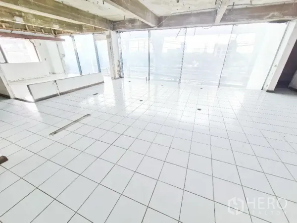 店屋 出租在Bang Na, Bangkok - 采光充足的展示楼层，白色地砖与落地窗引入大量自然光。