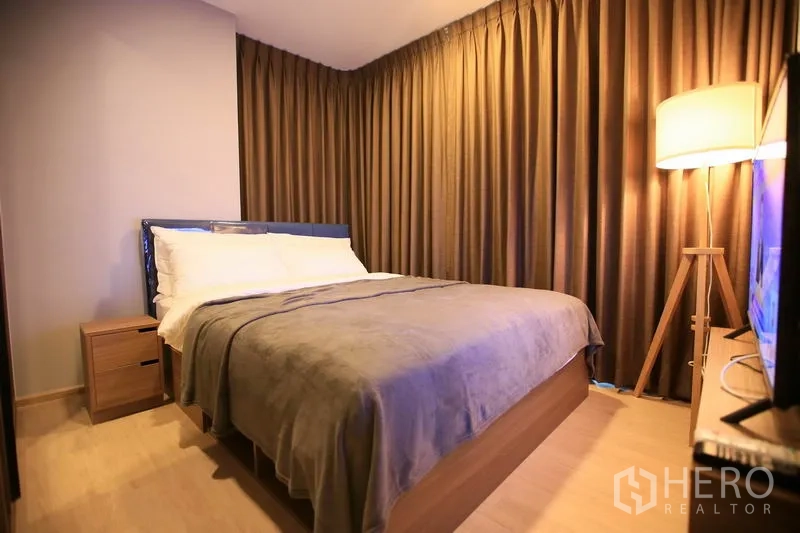 คอนโด ให้เช่าหรือขายในWatthana, Bangkok - ห้องนอนหลักเตียงควีน ไฟตั้งพื้น และผ้าม่านทึบแสงเต็มความสูง