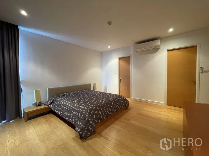 คอนโด ให้เช่าหรือขายในWatthana, Bangkok - ห้องนอนหลักกว้าง เตียงคิงไซส์ พื้นไม้ แอร์ และประตูเข้าสู่ห้องน้ำและห้องแต่งตัว.