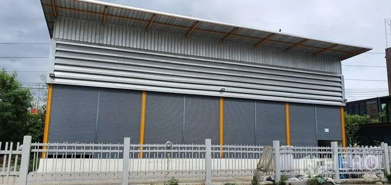 คลังสินค้า ให้เช่าในKhlong Toei, Bangkok - ด้านหน้าอาคารโกดังกรุงเทพฯ ผนังเมทัลชีท ชายคายื่นยาว พร้อมรั้วและที่จอดรถ