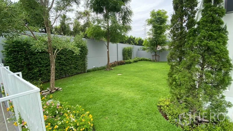 联排别墅 出租在Prawet, Bangkok - 宽阔私人花园，绿草坪、树木和高隐私围墙。