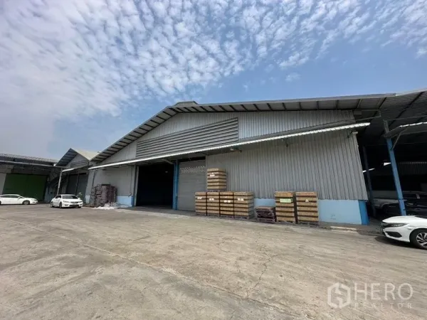 货栈 出租在Bang Pa-in, Phra Nakhon Si Ayutthaya - 仓库门面带有有顶装卸区，露天场地摆放托盘。