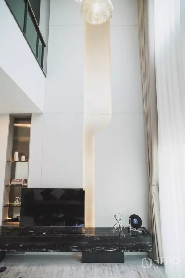 Detached House for rent in Bang Phli, Samut Prakan - Feature wall with subtle lighting, floating black marble TV console and floor-to-ceiling drapes.