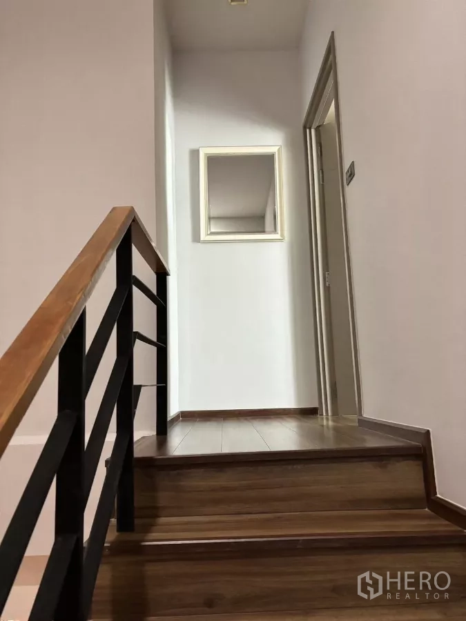 Condominium for rent or sale in Watthana, Bangkok - Staircase with metal railing leading to the upper-floor bedrooms.