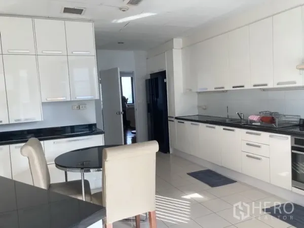 Condominium for rent in Yan Nawa, Bangkok - White modern kitchen with ample cabinets and a breakfast nook.