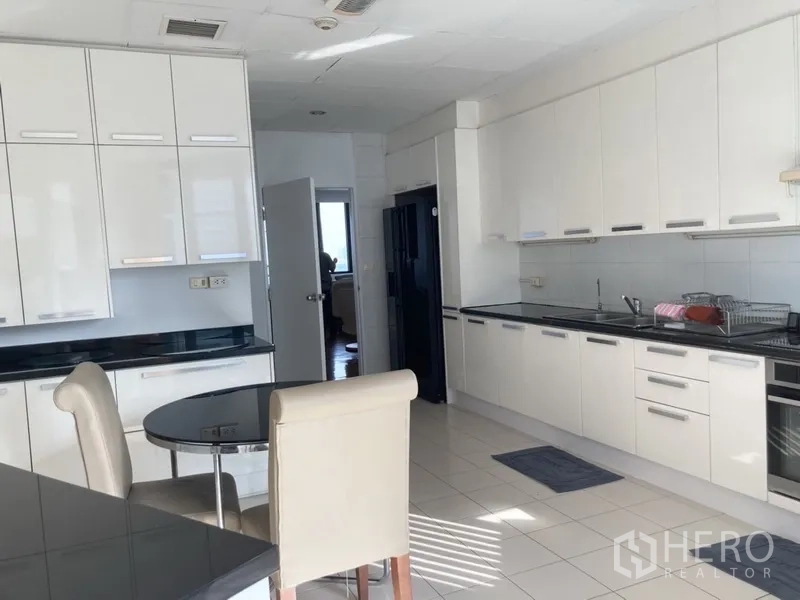 Condominium for rent in Yan Nawa, Bangkok - White modern kitchen with ample cabinets and a breakfast nook.