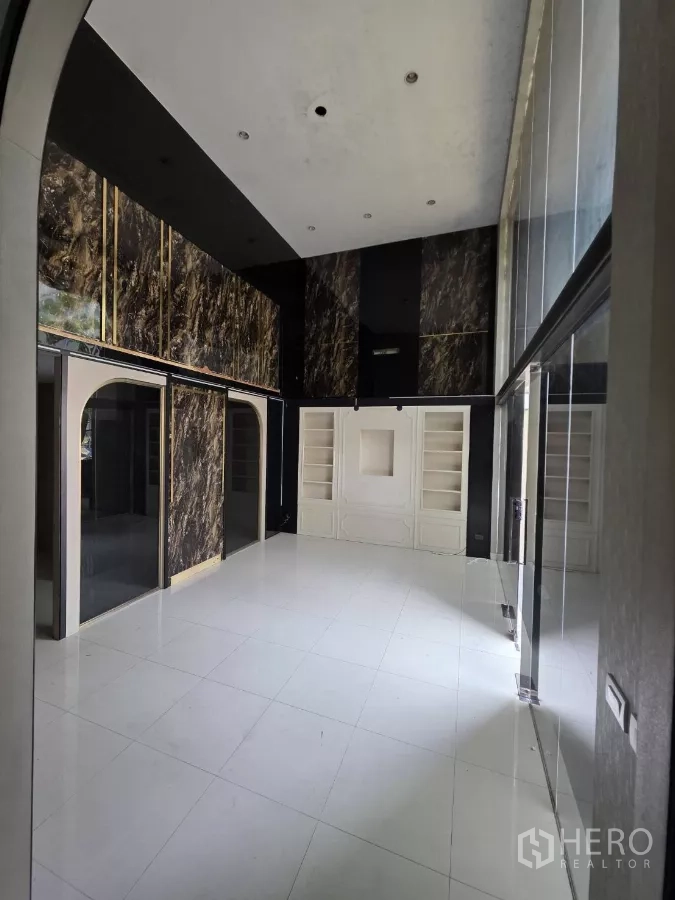 Home Office for rent in Pak Kret, Nonthaburi - High-ceiling lobby with marble accents, built-in shelving and white tiled floors ideal for a showroom.