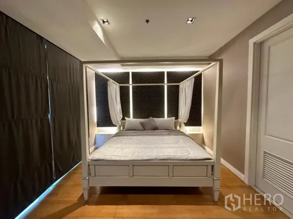 Condominium for rent in Pathum Wan, Bangkok - Master bedroom featuring a white four-poster bed and illuminated headboard.