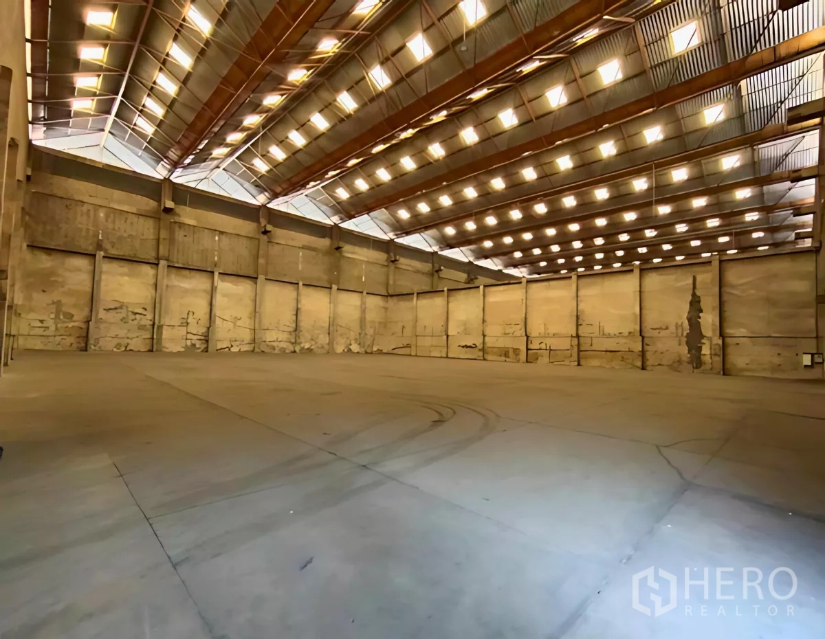 工厂 出租在Samut Prakan - 高挑顶、天窗与混凝土地面的宽敞工厂内部空间（Samut Prakan）。