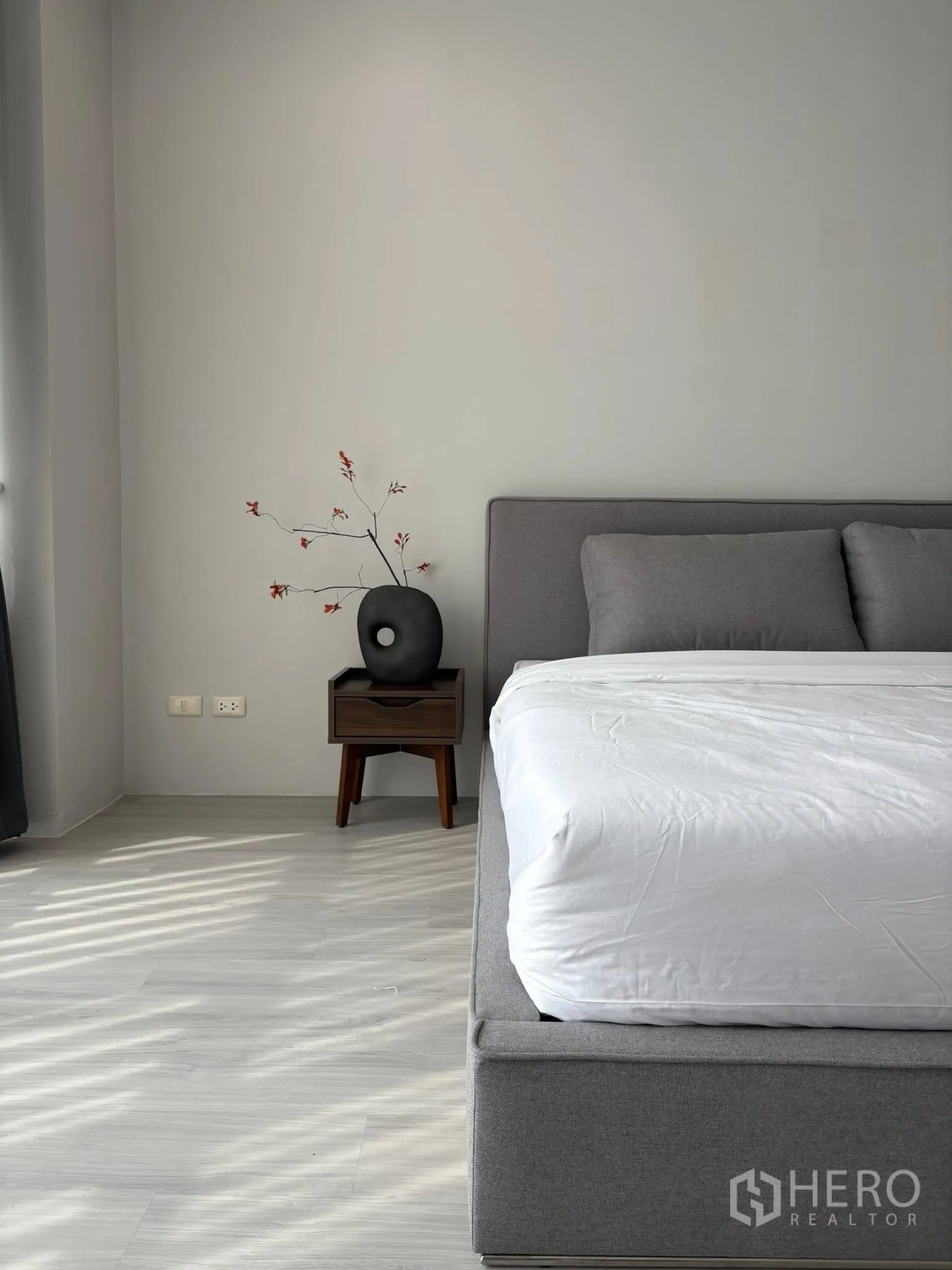 คอนโด for rent in Ratchathewi, Bangkok - มุมข้างเตียงพร้อมหัวเตียงสีเทา โต๊ะข้าง และแจกันตกแต่ง