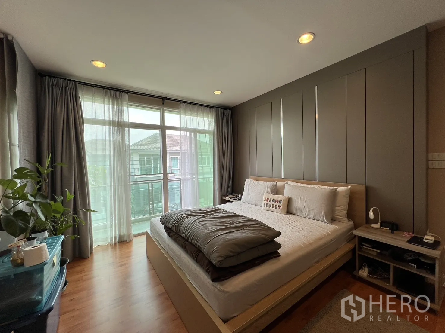 Detached House for rent or sale in Saphan Sung, Bangkok - Spacious bedroom with large windows, curtains and wood floors.