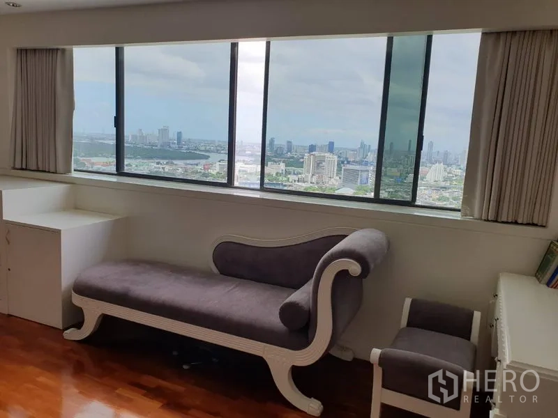 公寓 出租在Khlong Toei, Bangkok - 靠窗贵妃椅的阅读角，超大落地窗俯瞰曼谷天际线。