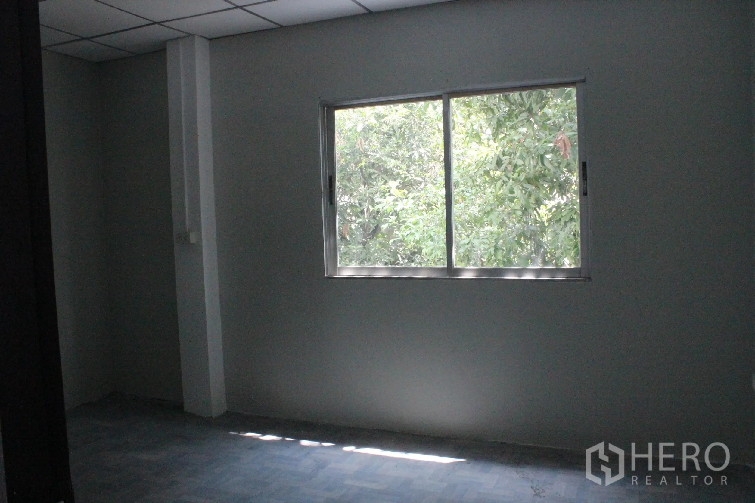 Home Office for rent in Khlong Toei, Bangkok - Private office room with a window facing green trees.