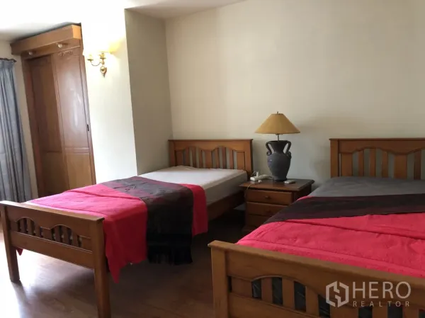 คอนโด ให้เช่าในPathum Wan, Bangkok - ห้องนอนรองมีเตียงเดี่ยวไม้สองเตียง โต๊ะหัวเตียงพร้อมโคมไฟ และตู้เสื้อผ้าบิลท์อิน