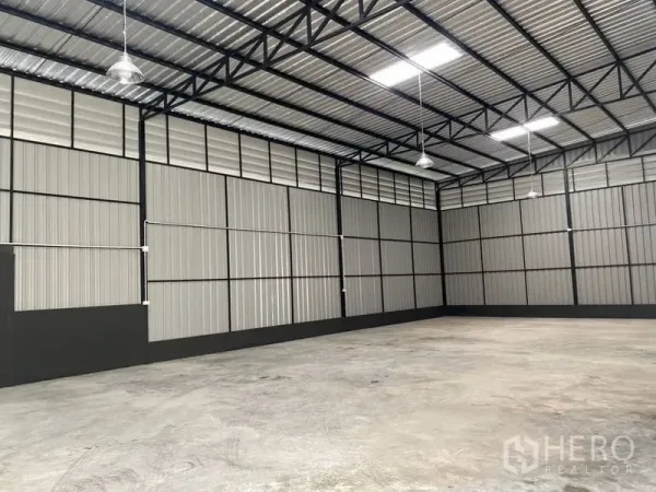 Warehouse for rent in Wang Thonglang, Bangkok - Column-free storage hall with metal cladding walls, pendant lights and a high ceiling.
