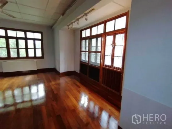 Detached House for rent in Pathum Wan, Bangkok - Bright room with large wood-framed windows and track lighting.