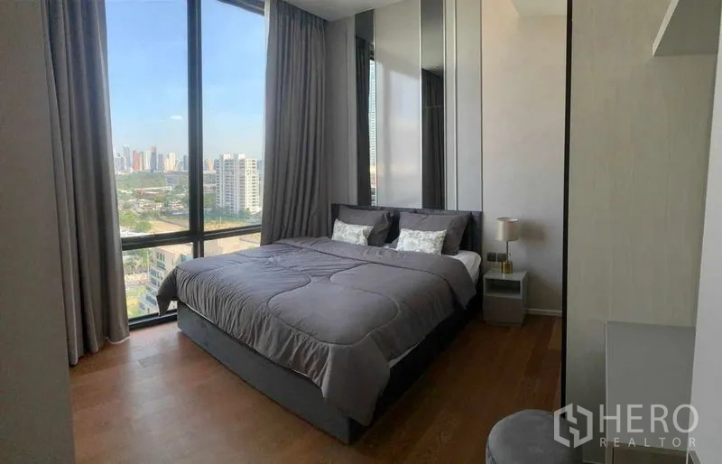 คอนโด ให้เช่าในPathum Wan, Bangkok - ห้องนอนสว่างในคอนโดปทุมวันให้เช่า หน้าต่างบานใหญ่เห็นวิวสกายไลน์และพื้นไม้