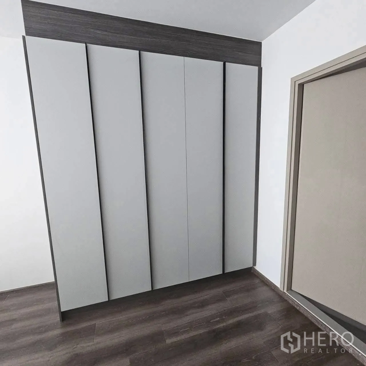 公寓 for rent in Huai Khwang, Bangkok - 到顶内置衣柜，灰色面板与深色木地板。