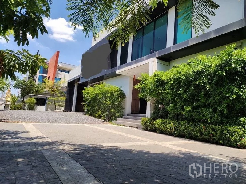 คลังสินค้า ขายในLat Krabang, Bangkok - ทางเข้าด้านหน้าอาคารกระจก ทางเดินคอนกรีตและต้นไม้ให้ร่มเงา