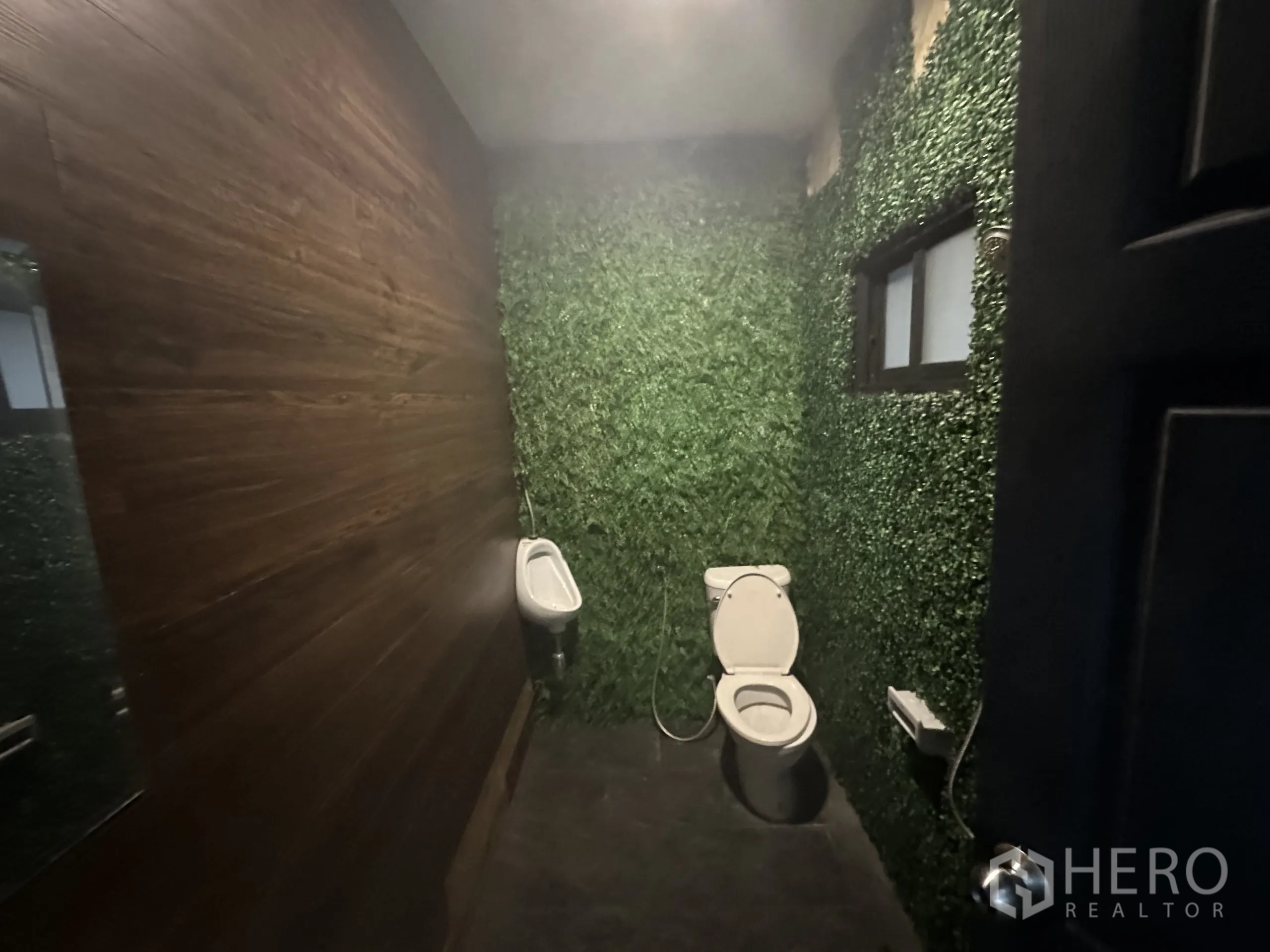 零售空间 出租在Suan Luang, Bangkok - 卫生间，绿色植物墙装饰与木质点缀面。